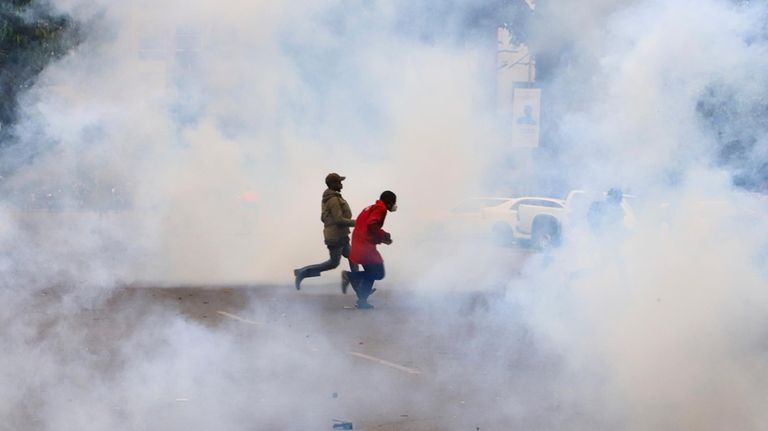 Protestors run through clouds of tears during anti-government protests in...