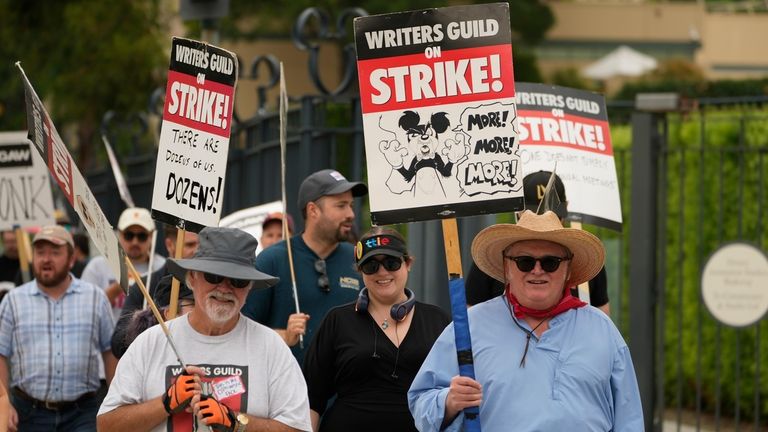 Writers Brent Mote, left, and Mark McCorckle, right, picket outside...