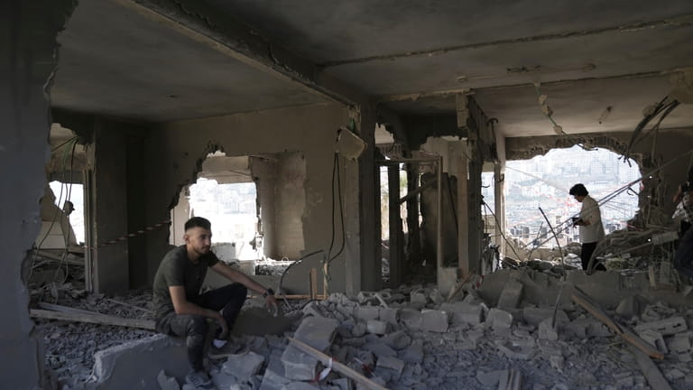 Palestinians clear rubble after Israeli forces demolished the home of...