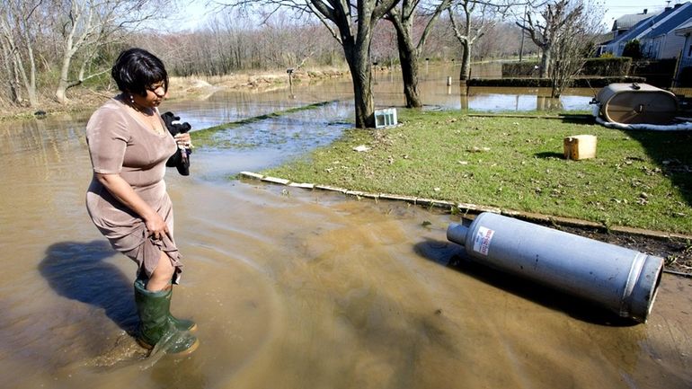 Linda Hobson, still wearing her church clothes, wades through water...