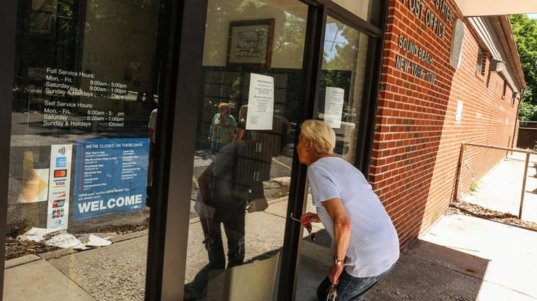Inge Goldstein, of Sound Beach, peers into the post office...