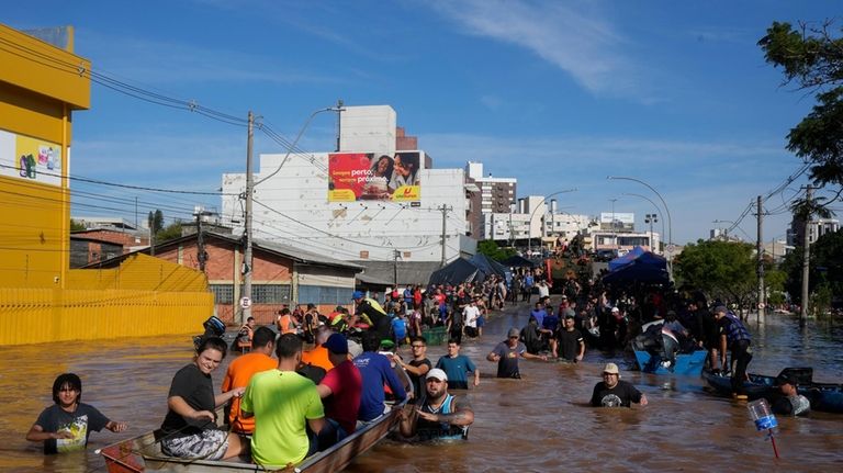 Volunteers gather in order to help residents evacuate from an...