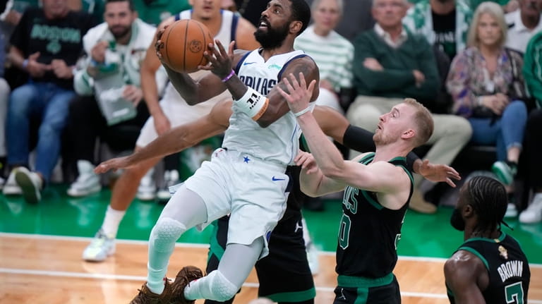 Dallas Mavericks guard Kyrie Irving, front left, drives to the...