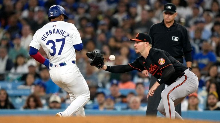 Los Angeles Dodgers' Teoscar Hernández, left, is safe at first...