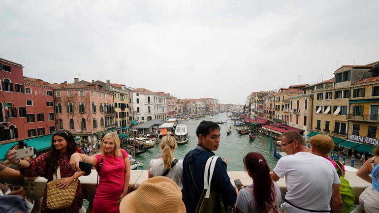 FILE -Tourists visit Rialto bridge, in Venice, Italy, Wednesday, Sept....