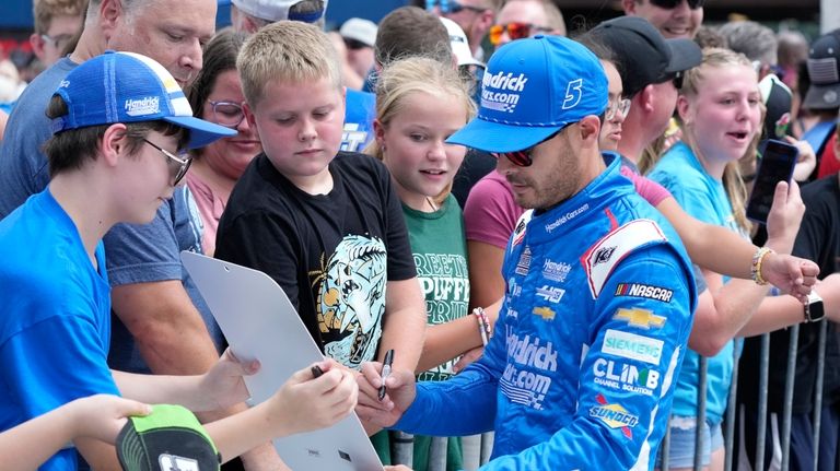 Kyle Larson signs autographs before driver introductions of a NASCAR...