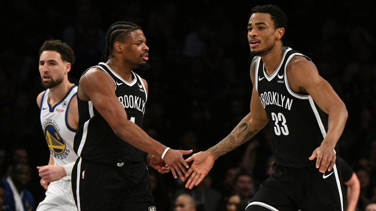 Nets center Nic Claxton and guard Dennis Smith Jr. react...