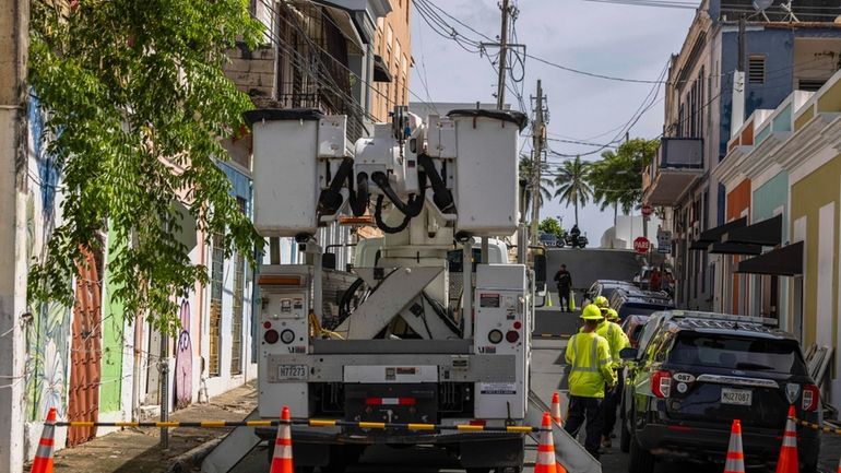 Electric workers carry out repairs in the community of Puerta...