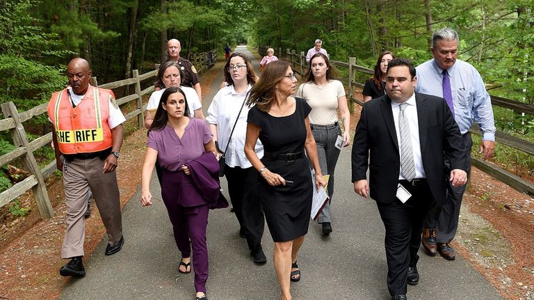 Superior Court Justice Amy Messer, center in black, walks along...