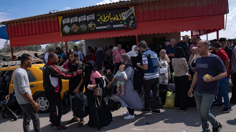 Palestinians wait to cross into Egypt at the Rafah border...