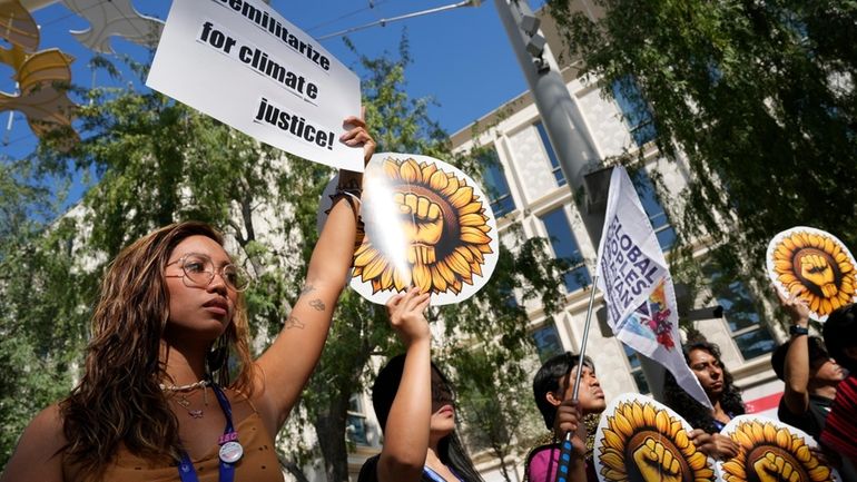 Mitzi Jonelle Tan, of the Philippines, holds a sign reading...