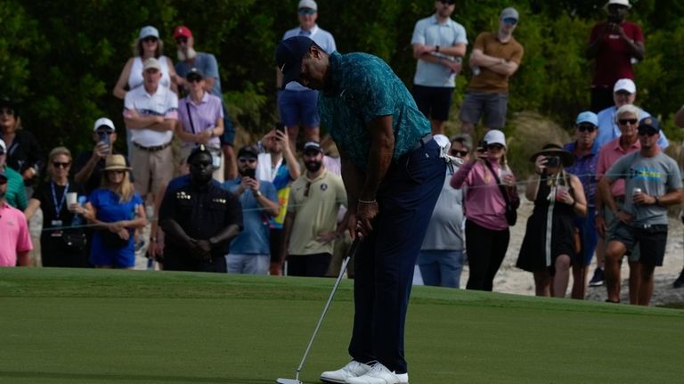 Tiger Woods watches his birdie on the first green during...