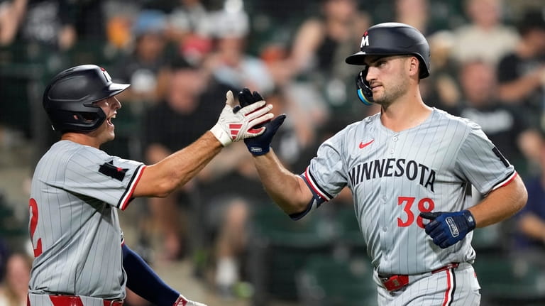 Minnesota Twins' Brooks Lee, left, greets Matt Wallner, right, after...