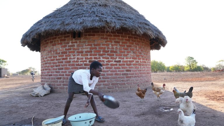 Esther Bote, 14, washes dishes outside her family home on...