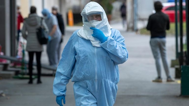 A health worker on Tuesday wears protective suit at the...