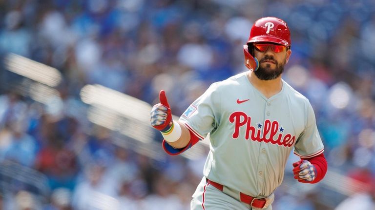 Philadelphia Phillies designated hitter Kyle Schwarber gestures after hitting a...