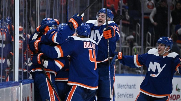 New York Islanders players celebrate their 3-2 overtime win against...