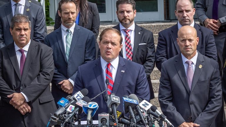 Suffolk County District Attorney Raymond Tierney, center, speaks at a...