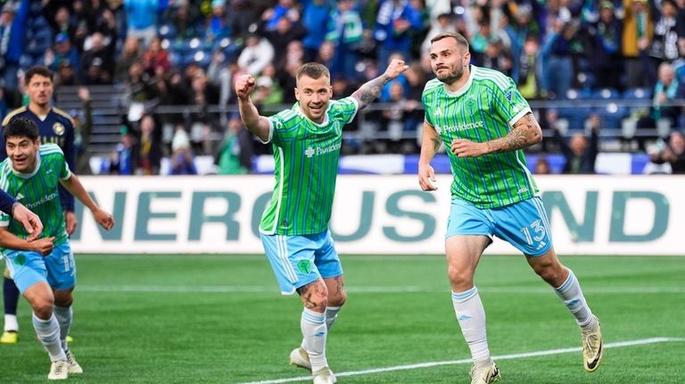 Seattle Sounders forward Jordan Morris, right, reacts with midfielder Albert...