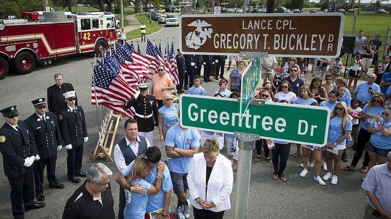 Shane Buckley embraces his mother, Marina, after a street sign...