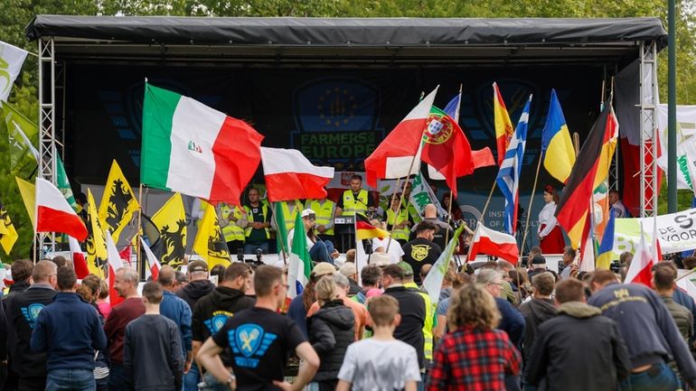 Farmers hold flags of European countries as they gather to...