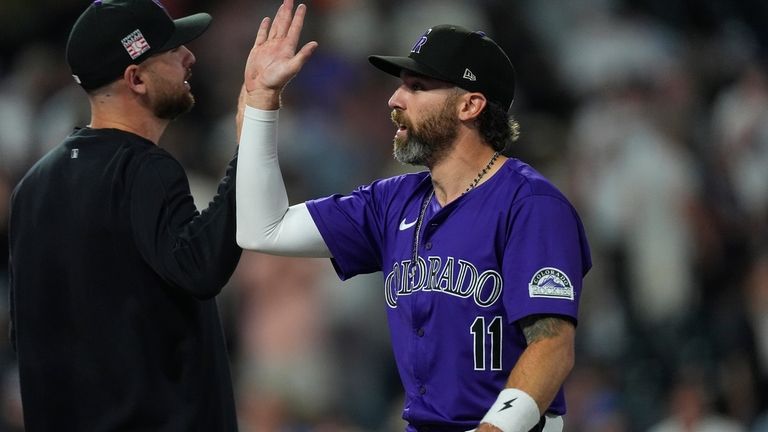 Colorado Rockies right fielder Jake Cave, right, is congratulated after...