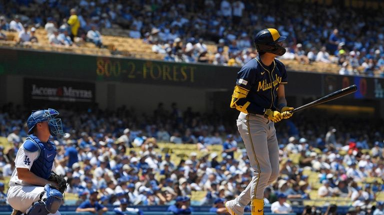 Milwaukee Brewers' Christian Yelich, right, heads to first for a...