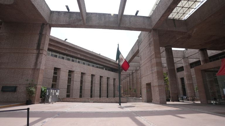 A Mexican flag stands amid the empty corridors of the...