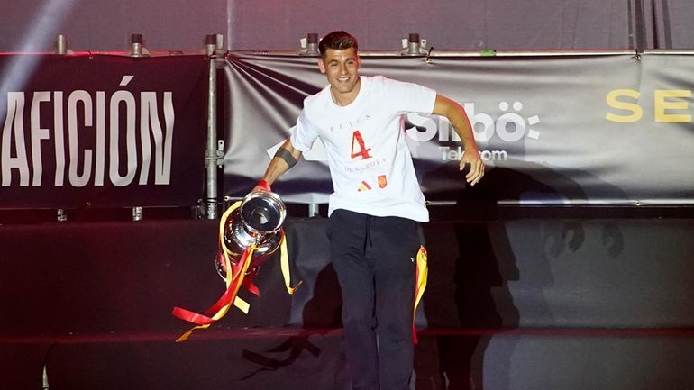 Spain's team captain Alvaro Morata arrives on stage carrying the...