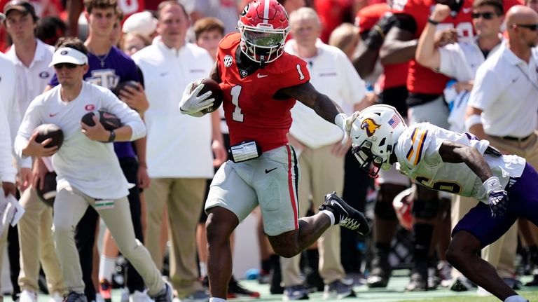 Georgia running back Trevor Etienne (1) fends off Tennessee Tech...