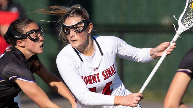 Mount Sinai midfielder Peyton Choma, center, plays against Sayville on...