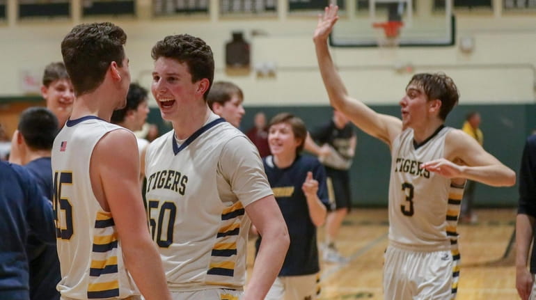 From left, Northport's George Mansour, Nick Watts and Pat Healy celebrate after Northport defeated...