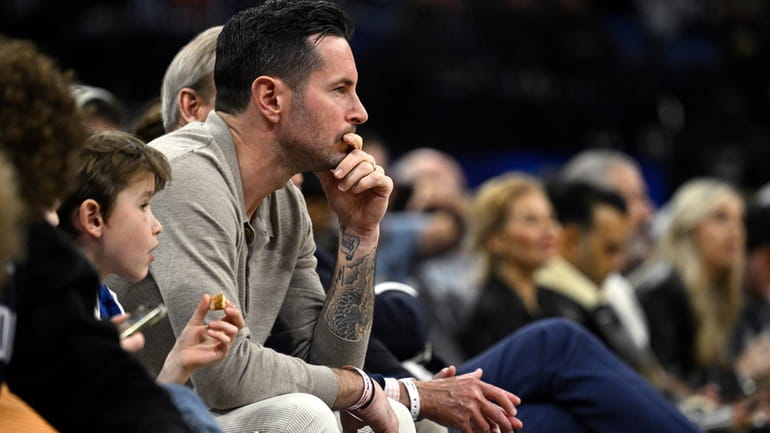 Former Orlando Magic guard JJ Redick, center, watches from a...