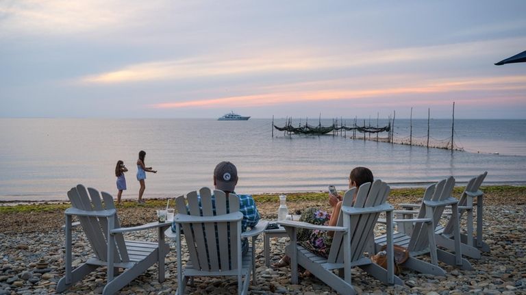 Customers watch the sunset at Navy Beach in Montauk.