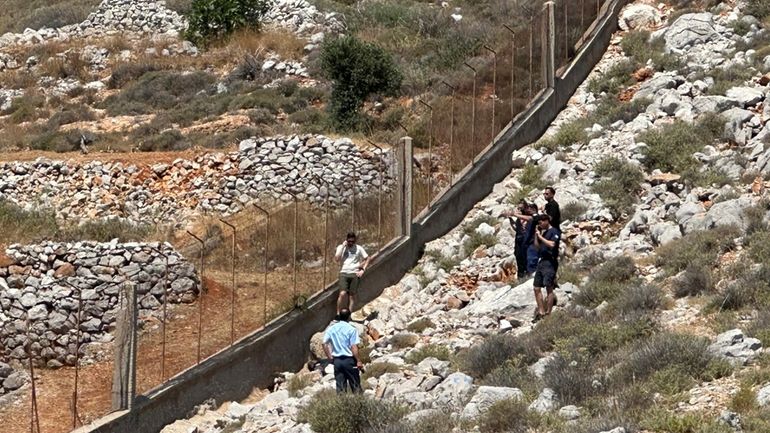 Firemen and policemen stand around the body of missing British...