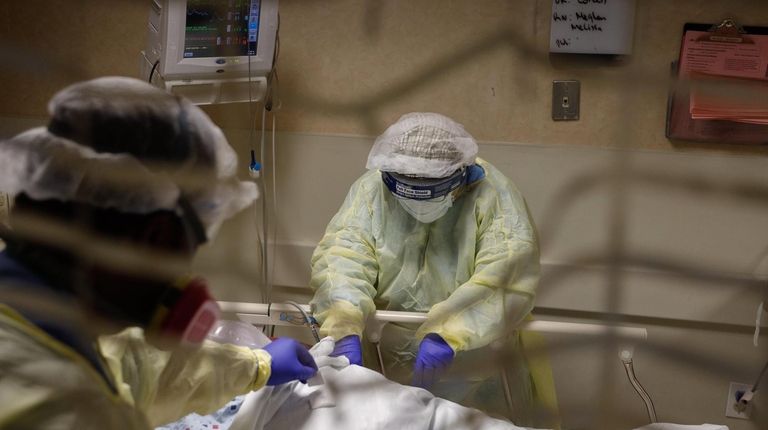 Medical staff assist a COVID-19 patient who was crying out...