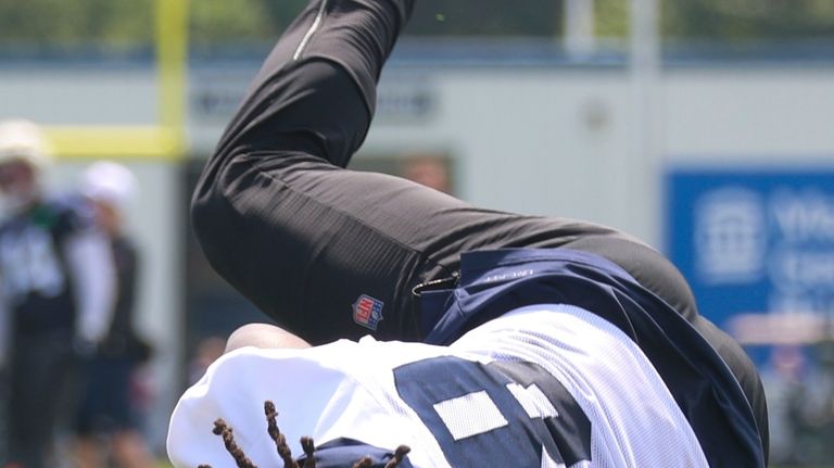 New England Patriots' Rhamondre Stevenson hits the ground during an...