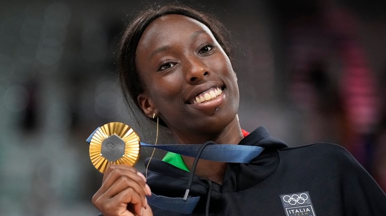 Paola Egonu of Italy shows her gold medal after the...