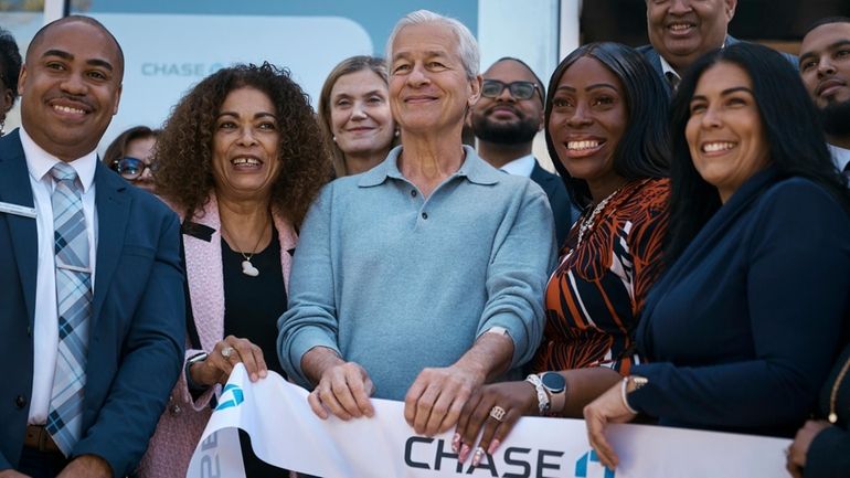 Jamie Dimon, CEO and chairman of JPMorgan Chase, center, attends...