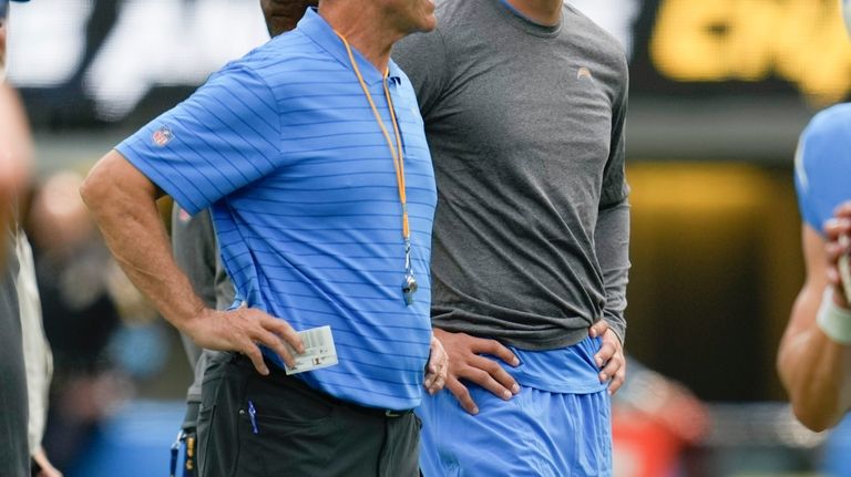 Los Angeles Chargers head coach Jim Harbaugh, left, talks with...