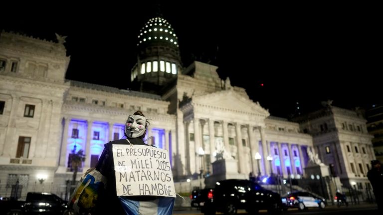 A demonstrator holds a banner that reads in Spanish "The...