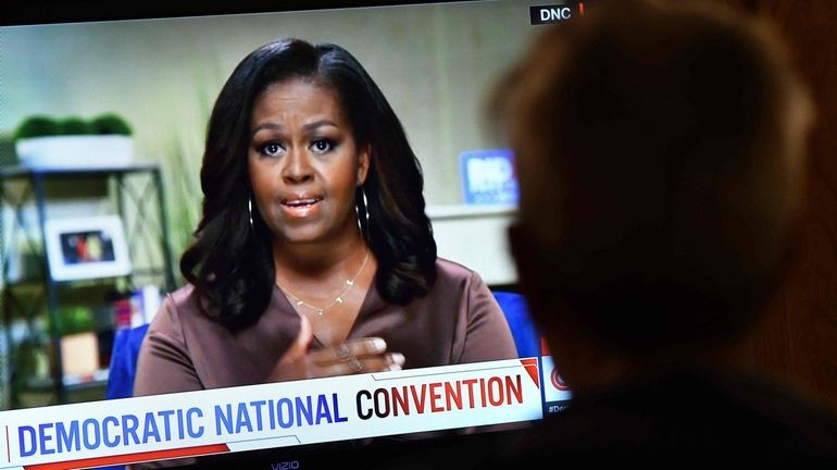 A person watches former first lady Michelle Obama's speech Monday,...