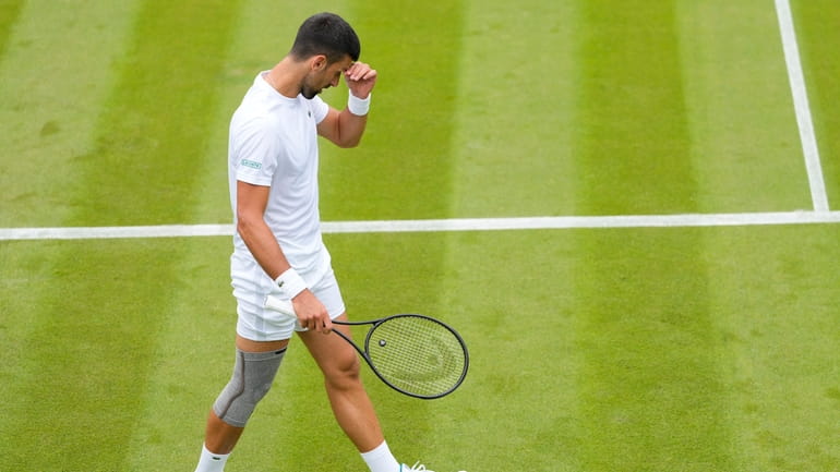 Novak Djokovic of Serbia wipes his face during a training...