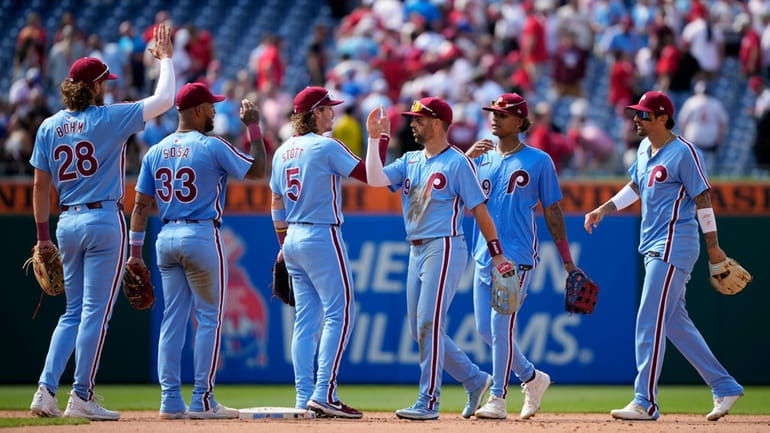 Philadelphia Phillies' players celebrate after winning a baseball game against...