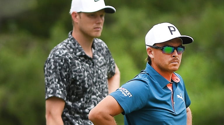 Cam Davis, left, and Rickie Fowler look over the eighth...