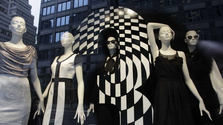 Mannequins are fashionably dressed in a Bloomingdale's store window in...