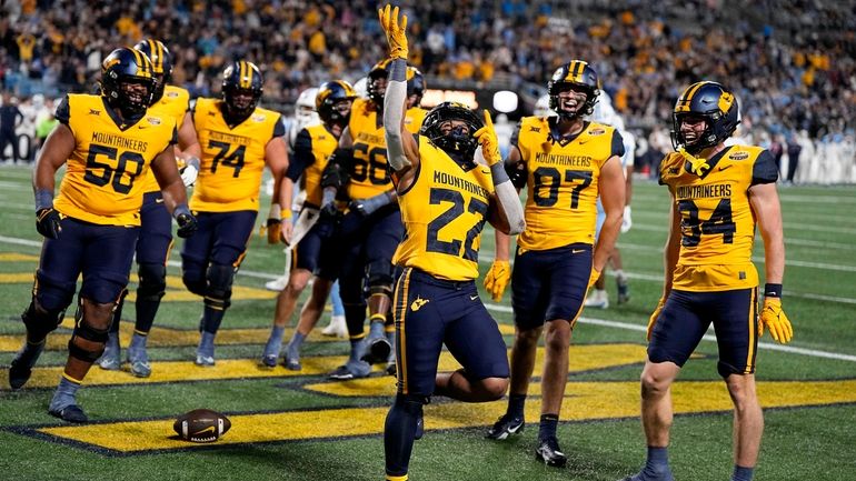 West Virginia running back Jahiem White (22) celebrates after scoring...