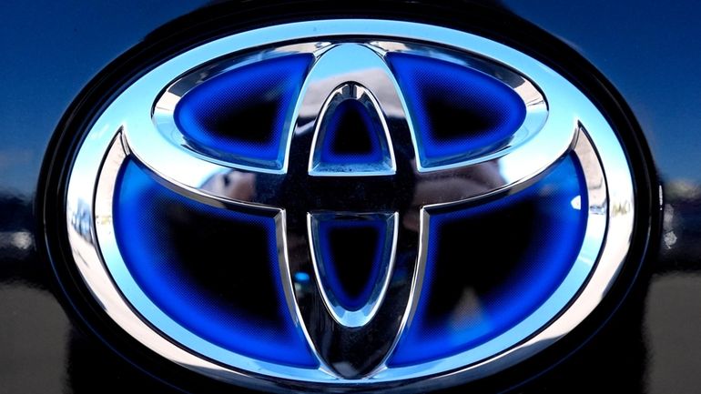 Toyota logo (Hybrid model) is seen at a new and...