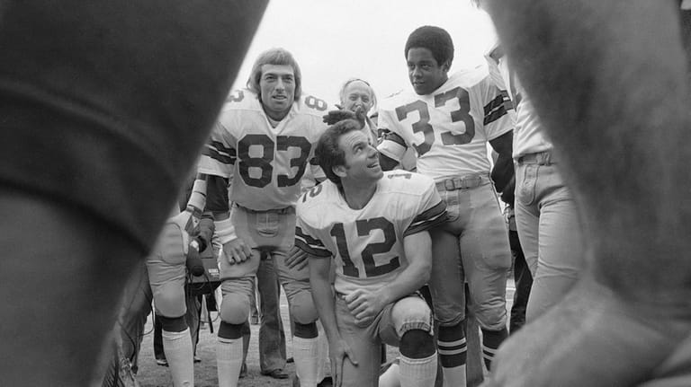 Dallas Cowboys quarterback Roger Staubach smiles up at Tony Dorsett...