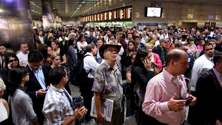 Passengers wait at Penn Station as LIRR service in and...